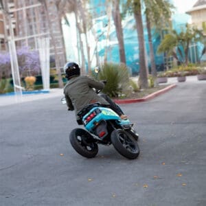 Back view of rider on blue XOTO 3-wheeled leaning electric scooter